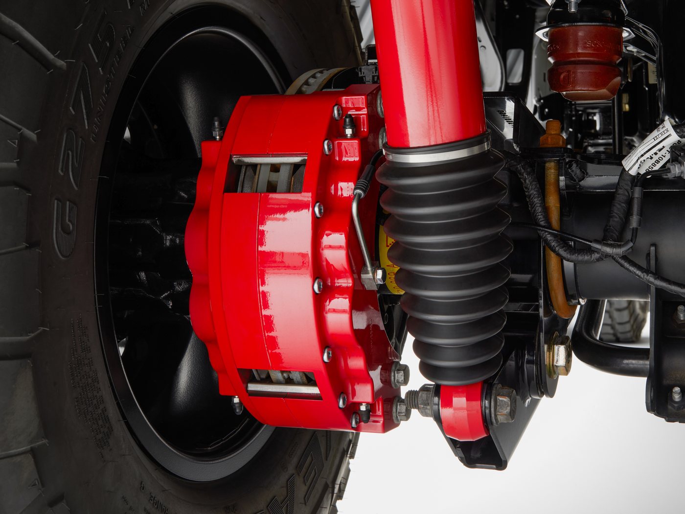 Front LiquidSpring strut and boot alongside the brake caliper on a lifted Ford F-450